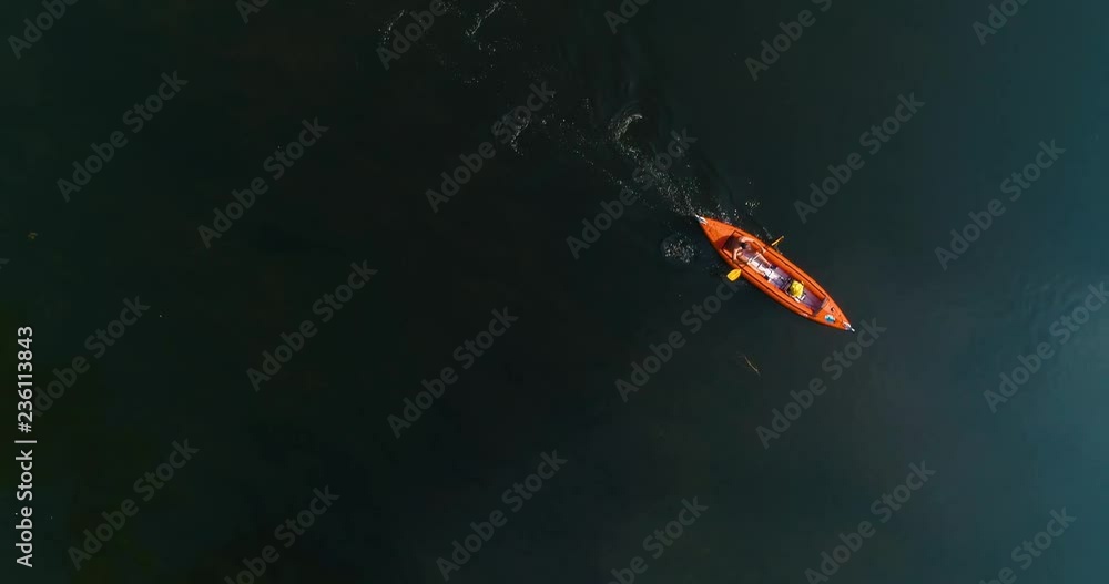 A Man Is Rowing In A Canoe Across The River Drone Video