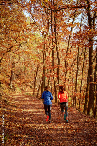 Young woman running in autumn forest.