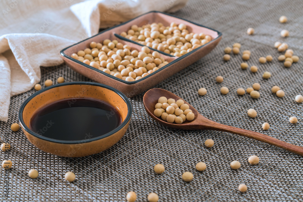 A dish of soy sauce and soybeans sprinkled on bamboo mats and spoons A dish of soy sauce and soybeans sprinkled on bamboo mats and spoons