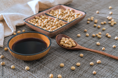 A dish of soy sauce and soybeans sprinkled on bamboo mats and spoons