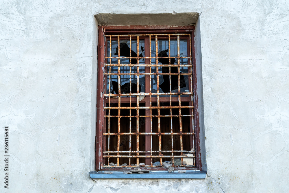 Broken glass window with bars