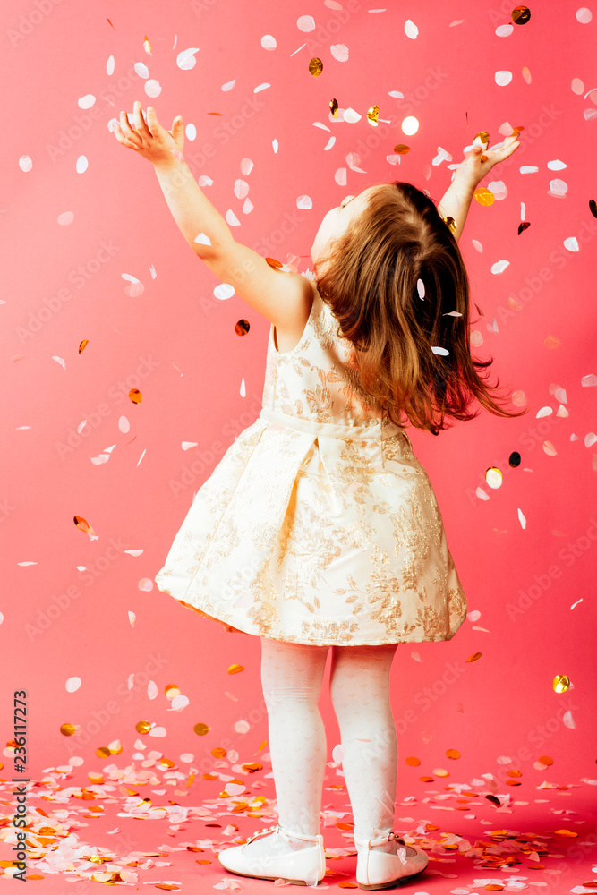 Studio shot of toddler girl throwing confetti StockFoto Adobe Stock