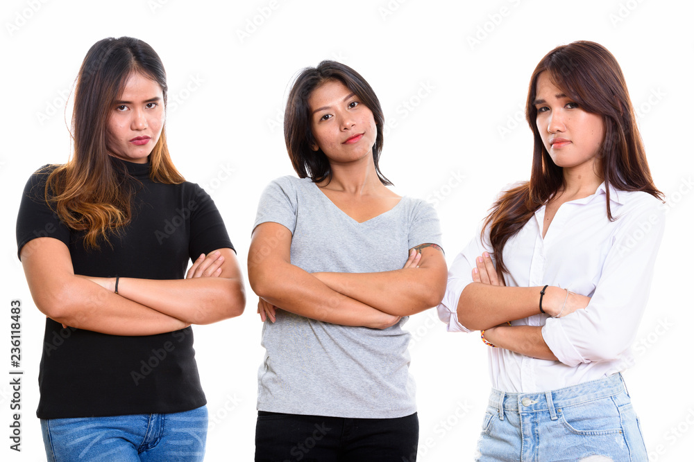 Studio shot of three young Asian woman friends with arms crossed Studio shot of three young Asian woman friends with arms crossed