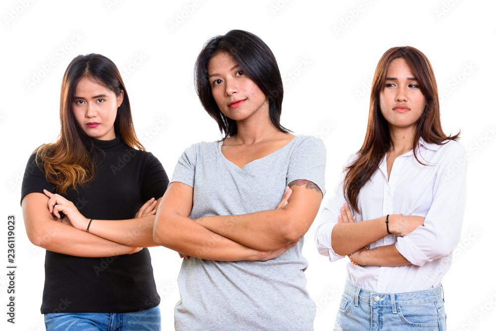 Studio shot of three young Asian woman friends with arms crossed Studio shot of three young Asian woman friends with arms crossed