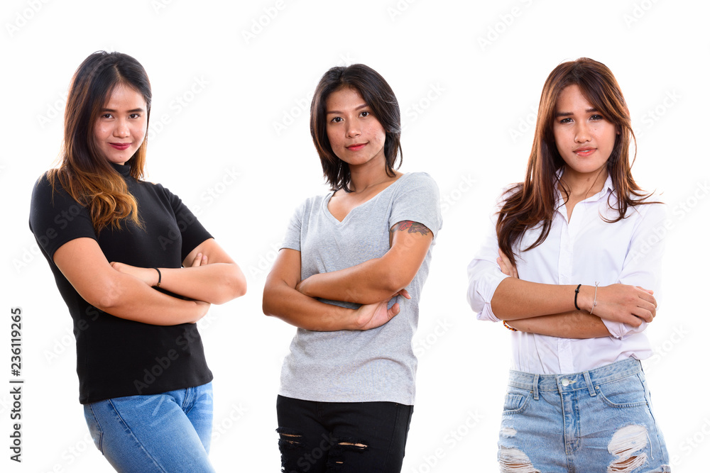 Studio shot of three young Asian woman friends with arms crossed Studio shot of three young Asian woman friends with arms crossed