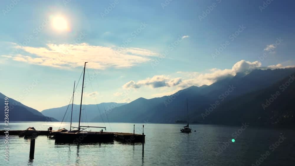 Sunlight over Alpine Lake Maggiore with a Port and Mountain in Ascona, Switzerland. Sunlight over Alpine Lake Maggiore with a Port and Mountain in Ascona, Switzerland.