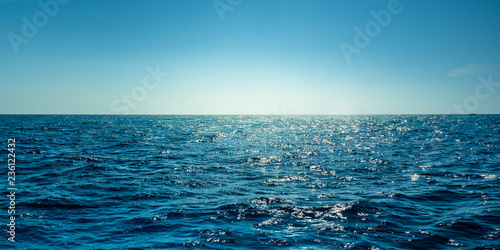 Fototapeta Naklejka Na Ścianę i Meble -  Blue ocean panorama with sun reflection, The vast open sea with clear sky, Ripple wave and calm sea with beautiful sunlight