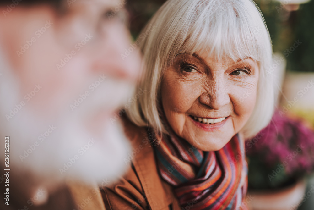 Close up portrait of joyful old woman looking at gentleman with love and smiling. Focus on female pensioner Close up portrait of joyful old woman looking at gentleman with love and smiling. Focus on female pensioner