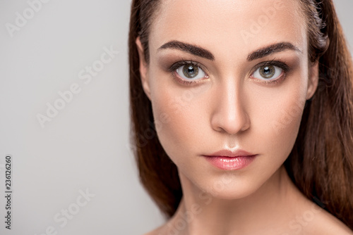 portrait of attractive young woman with perfect skin, isolated on grey