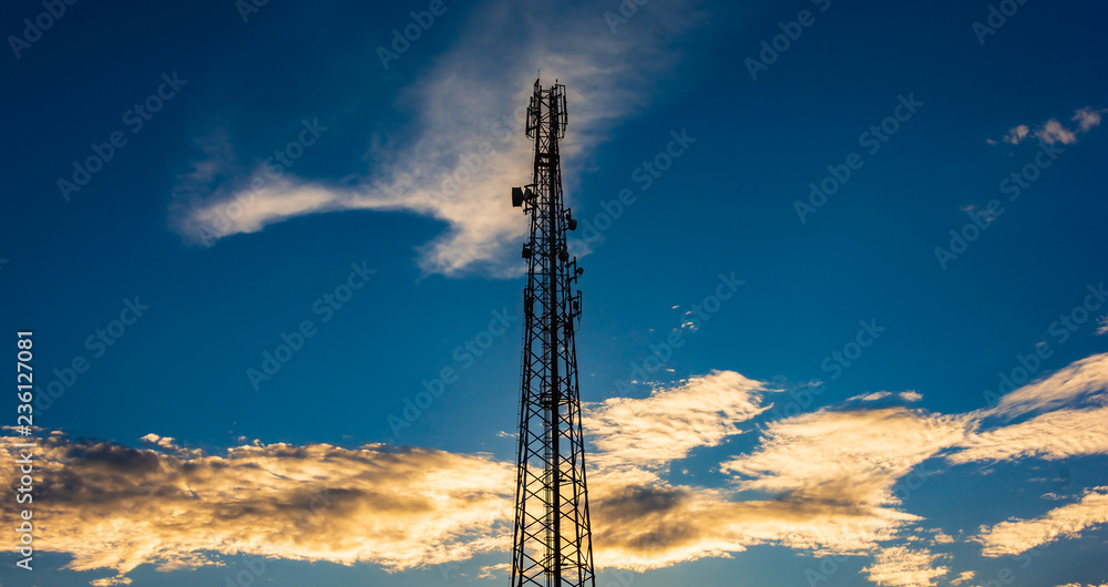 Telecommunication cellular tower in sunset sky.