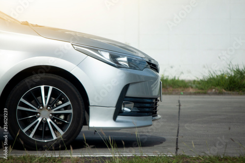 Side of the car on the concrete road in parking area.