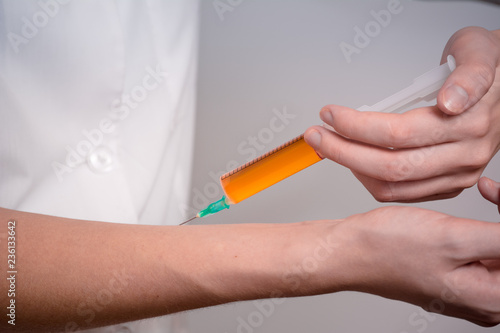 A doctor with a syringe makes an injection.