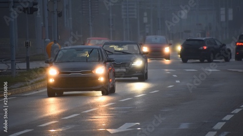 Cars in the fog. Bad winter weather and dangerous automobile traffic on the road. Light vehicles in foggy day. © montypeter