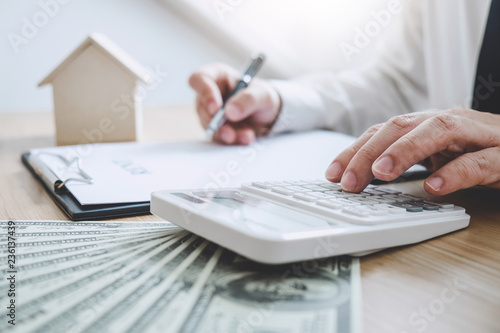 Businessman working doing finances and calculation cost of real estate investment while be signing to contract, Concept mortgage loan approval