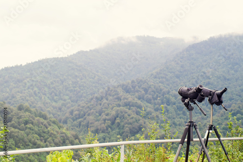 Foto Spotting scope or monoculars at mountain top against the background of a mountain landscape in summer day