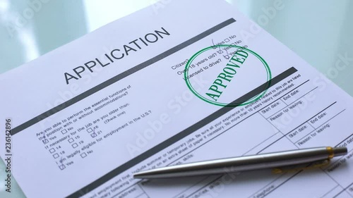 Application document approved, hand stamping seal on official paper, closeup