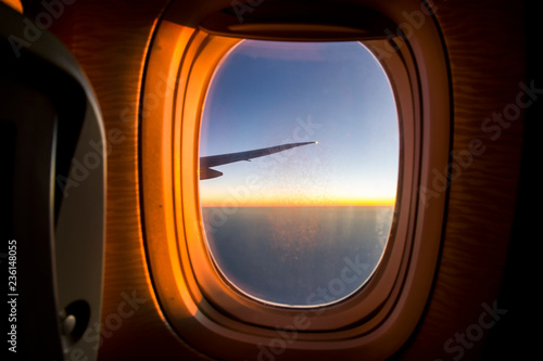 Airplane window during the flight sunset photo