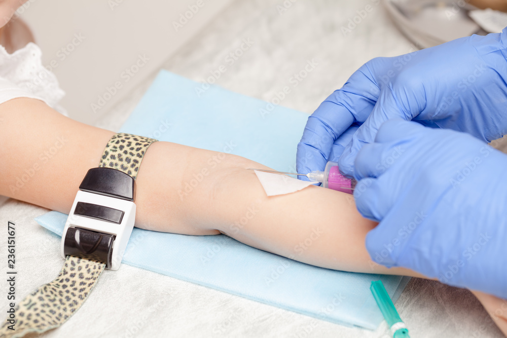 Nurse takes a blood sample from little girls arm - pediatric venipuncture  procedure