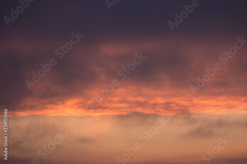 clouds at dawn. Fiery red rising sun behind the clouds. headpiece © Alexkarankevich