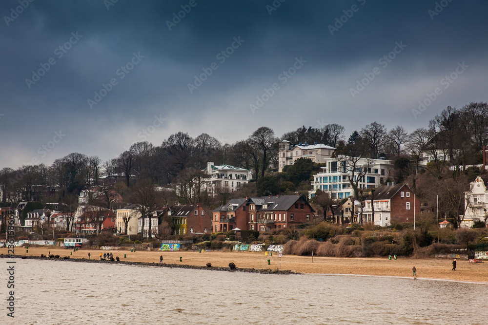 Beautiful houses and beaches on the banks of Elbe river in Hamburg on a cold end of winter day