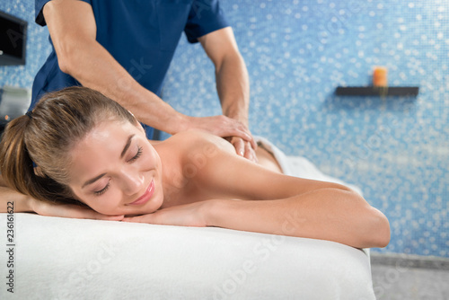 Selective focus of smiling woman during massage procedure