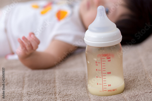 Close up of bottle of milk with infant