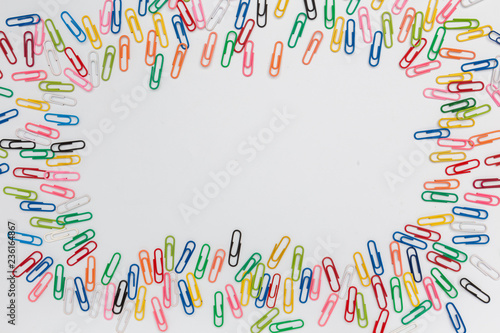 Colorful paper clips as frame isolated in white, top view, horizontal, with copy space