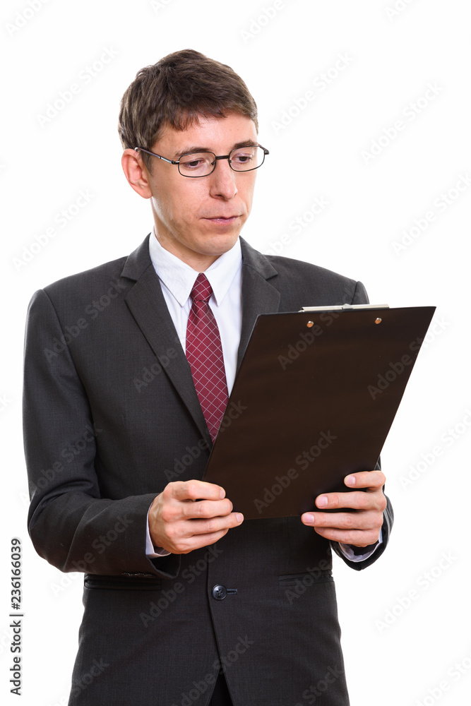 Studio shot of businessman reading on clipboard Studio shot of businessman reading on clipboard