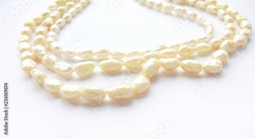 Natural river pearl beads on a gentle pearl necklace on a white background. Close up photography