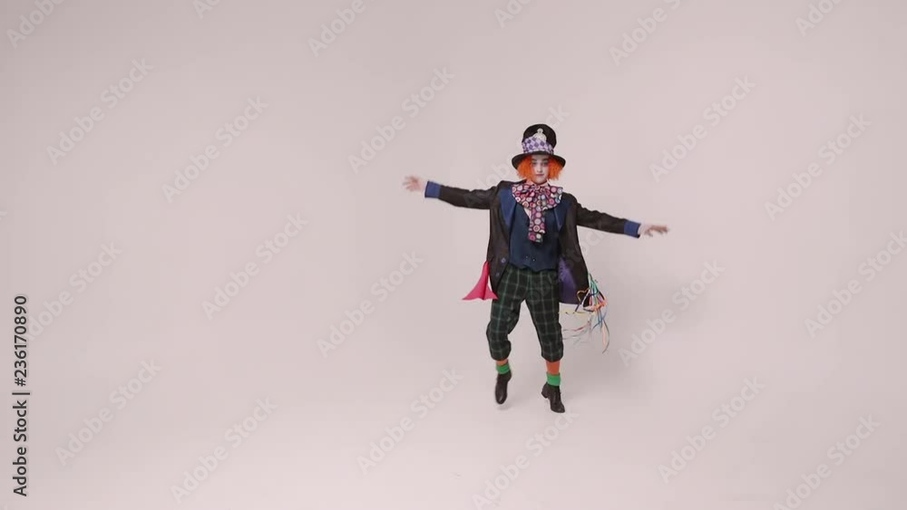 an actor in a hatter costume, he jumps and smiles. At white studio an actor in a hatter costume, he jumps and smiles. At white studio