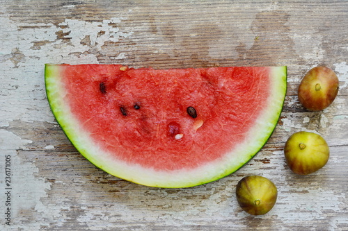 slice of watermelon and figs on a wooden table. photo