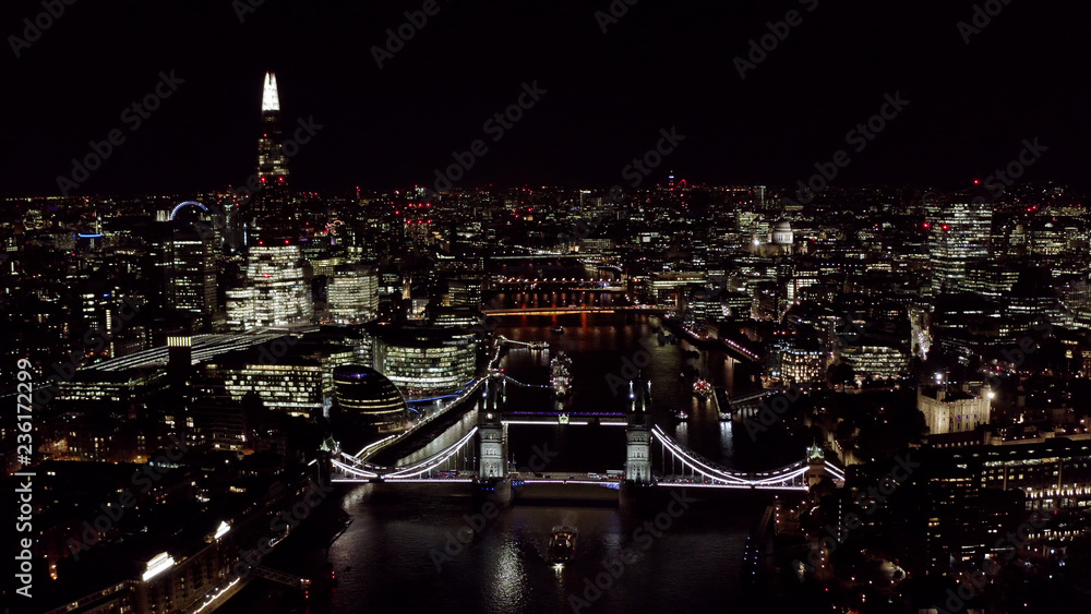 Fototapeta premium Beautiful Panoramic Night Aerial View of New London Cityscape and Landmarks around Tower Bridge and Thames River feat. Famous Skyscrapers