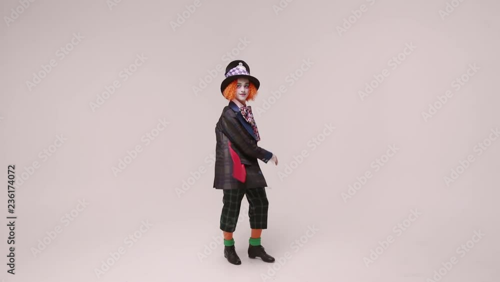 an actor in a hatter costume, he jumps and smiles. At white studio an actor in a hatter costume, he jumps and smiles. At white studio