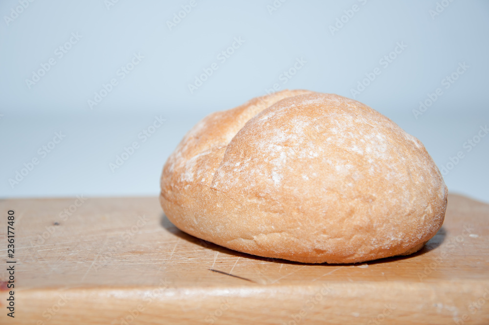 Hand cutting with a bun with a knife on a wooden chopping board Hand cutting with a bun with a knife on a wooden chopping board