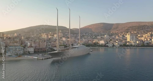 Aerial drone view of luxury yacht (Yacht A) parked in Saranda port in summer 2018.  Sarande, Albania at sunset - 4k