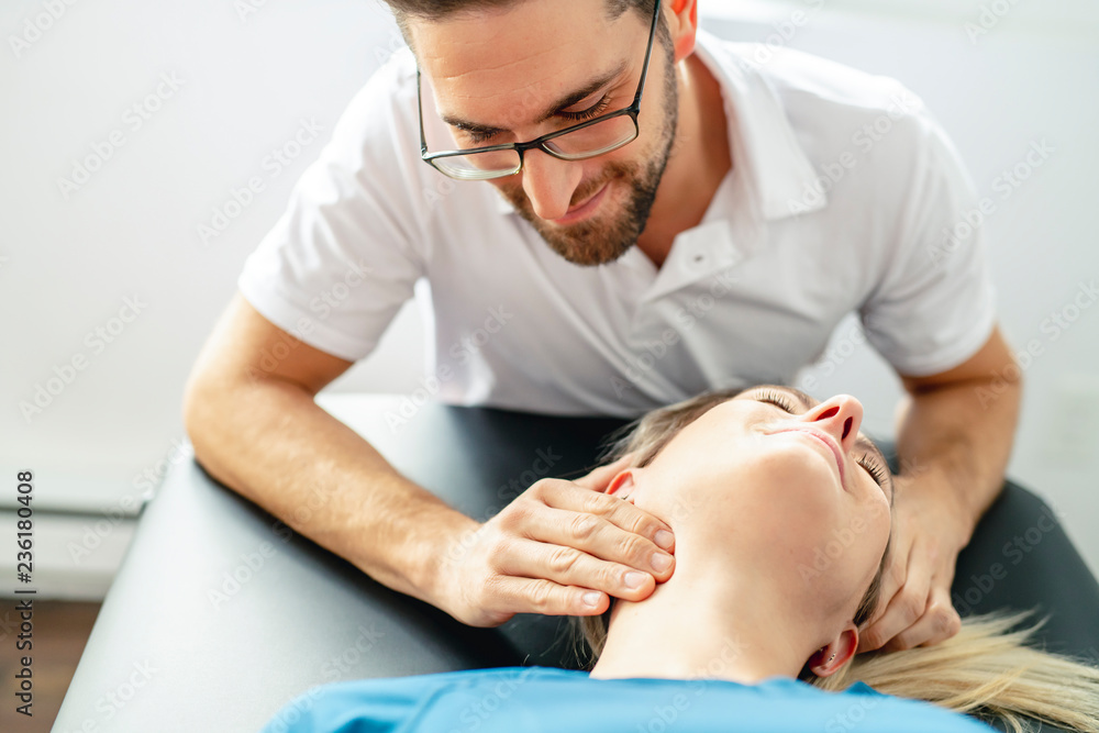 A Modern rehabilitation physiotherapy man at work with woman client woking on neck A Modern rehabilitation physiotherapy man at work with woman client woking on neck