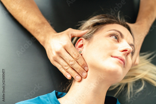 A Modern rehabilitation physiotherapy man at work with woman client woking on neck