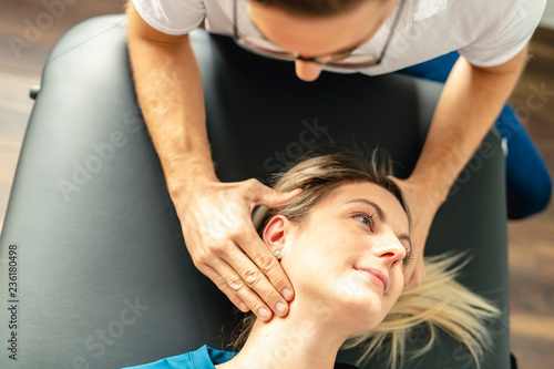 A Modern rehabilitation physiotherapy man at work with woman client woking on neck