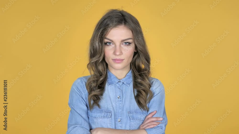 Young Girl Looking at Camera Isolated on Yellow Background Young Girl Looking at Camera Isolated on Yellow Background