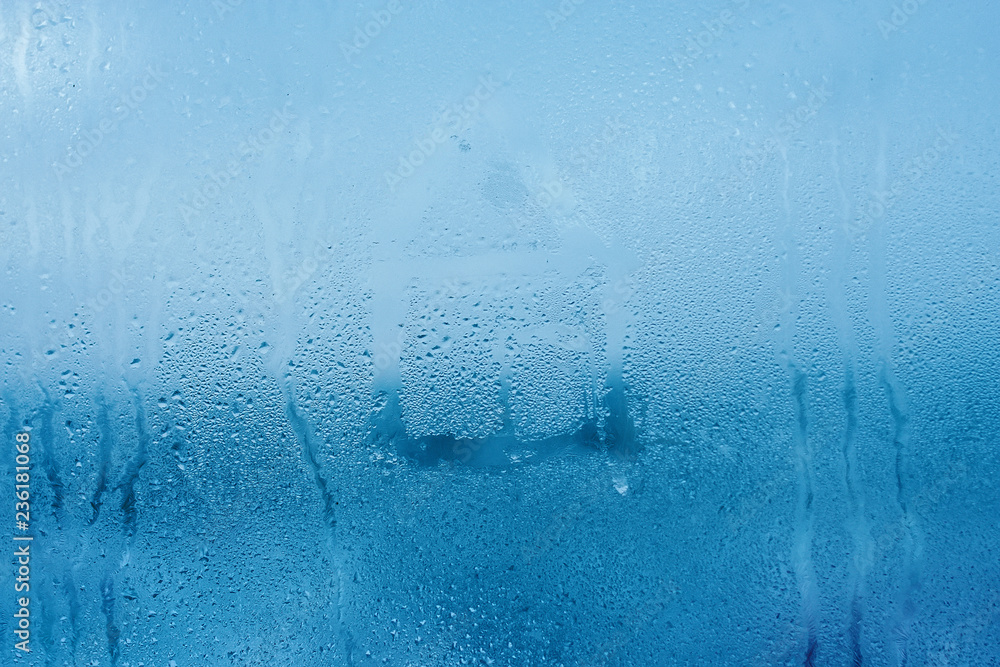 Fototapeta Hand drawn house on cold glass and water drops. Condensation in the window