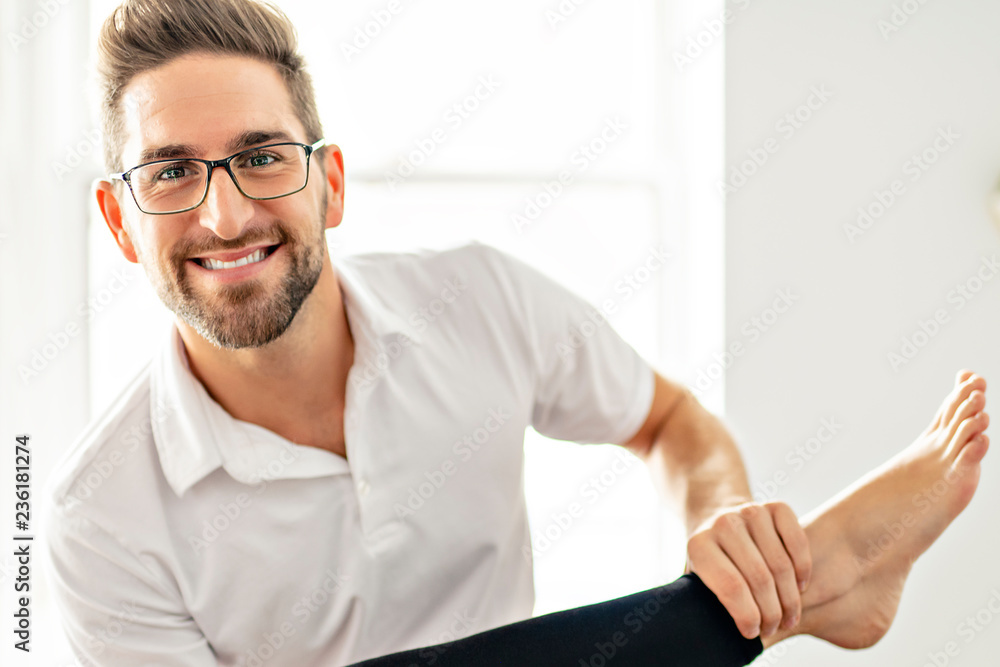 A Modern rehabilitation physiotherapy man at work with woman client working on leg A Modern rehabilitation physiotherapy man at work with woman client working on leg