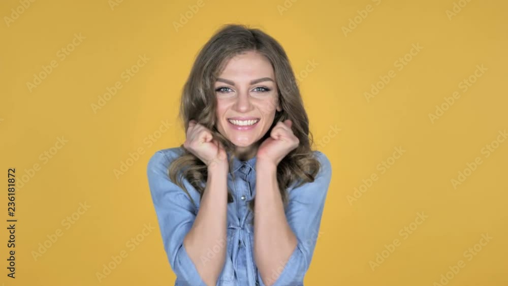 Happy Amazed Young Girl Surprised by Gift Isolated on Yellow Background Happy Amazed Young Girl Surprised by Gift Isolated on Yellow Background