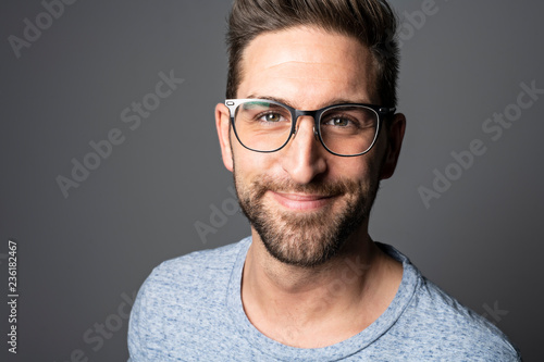 A Handsome man standing over dark grey background Portrait man concept. © Louis-Photo