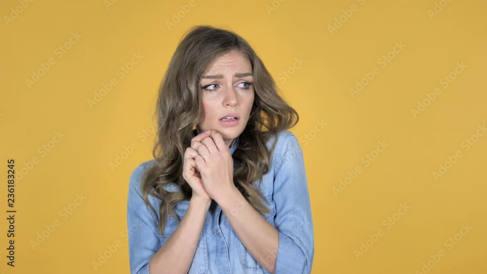 Young Girl Confused and Scared of Problems Isolated on Yellow Background Young Girl Confused and Scared of Problems Isolated on Yellow Background