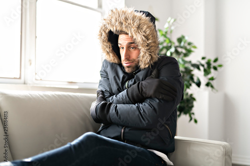 Foto A Man have cold on the sofa at home with winter coat