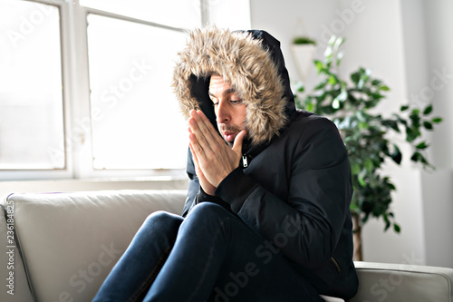 Murais de parede A Man have cold on the sofa at home with winter coat