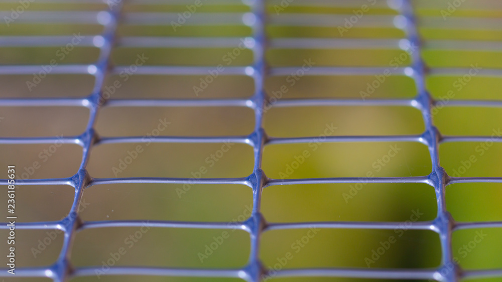 Fototapeta premium Green old metal mesh with selective focus. Close-up, abstract image