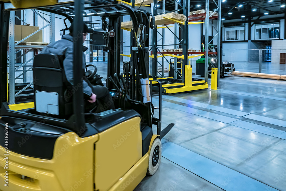 Forklift yellow. Warehouse automation. Boxes are on the shelves of the warehouse. Warehousing. Logistics in stock. Forklift rides through the warehouse.