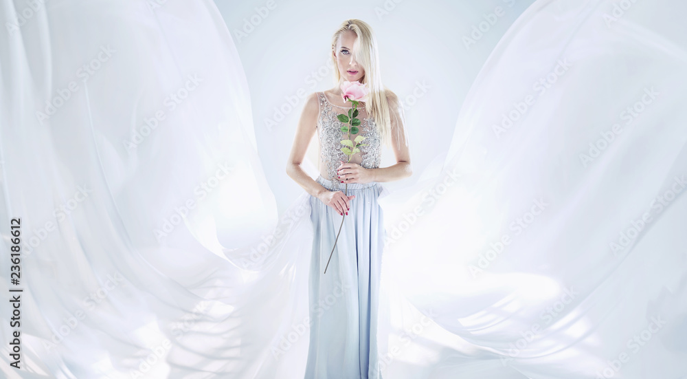 Elegant blond woman holding a long rose flower Elegant blond woman holding a long rose flower