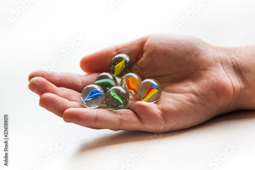 Wallpaper Mural Colorful game marbles in the hand of a child on white background Torontodigital.ca